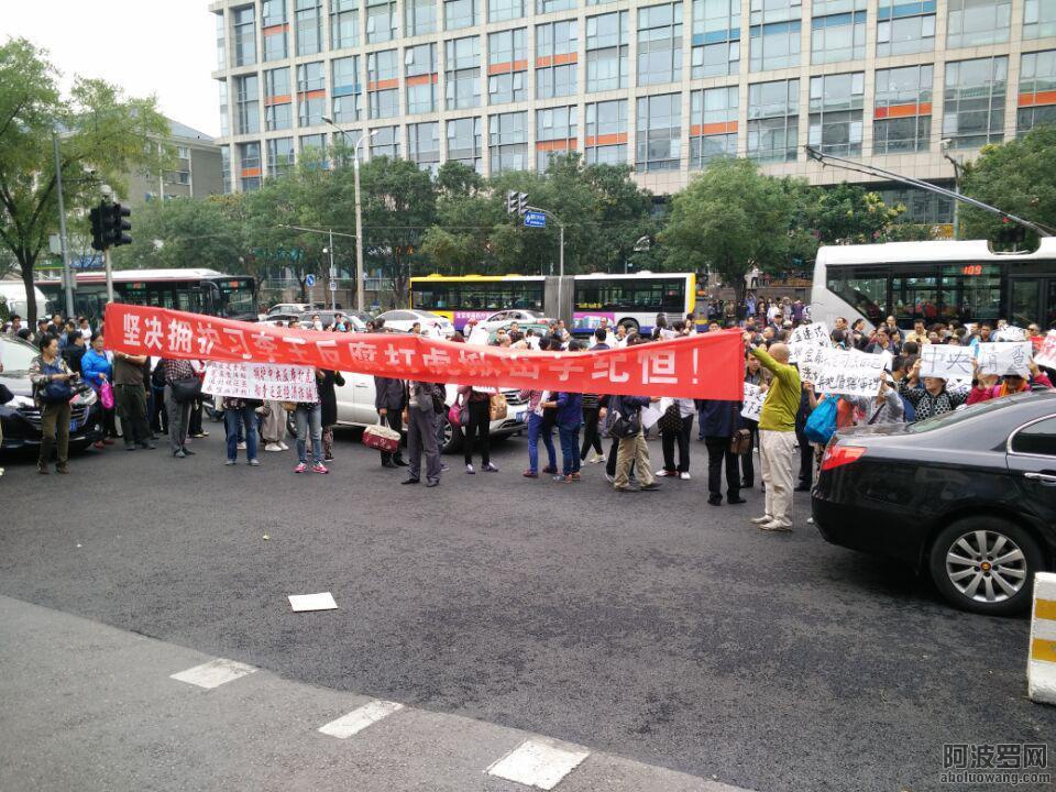 示威者在国新办外举牌喊打到李纪恒
